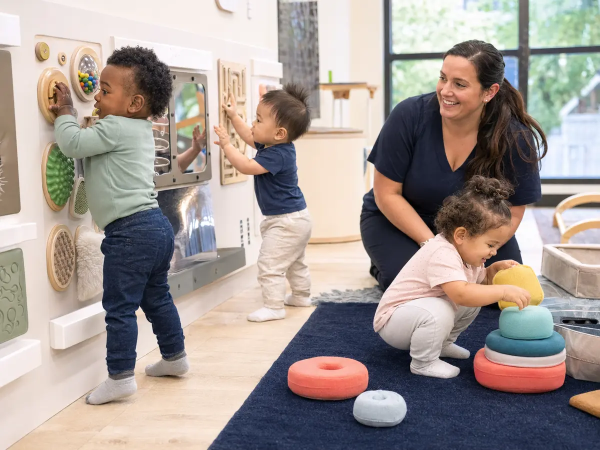 One-year-olds exploring sensory activities with a caring teacher
